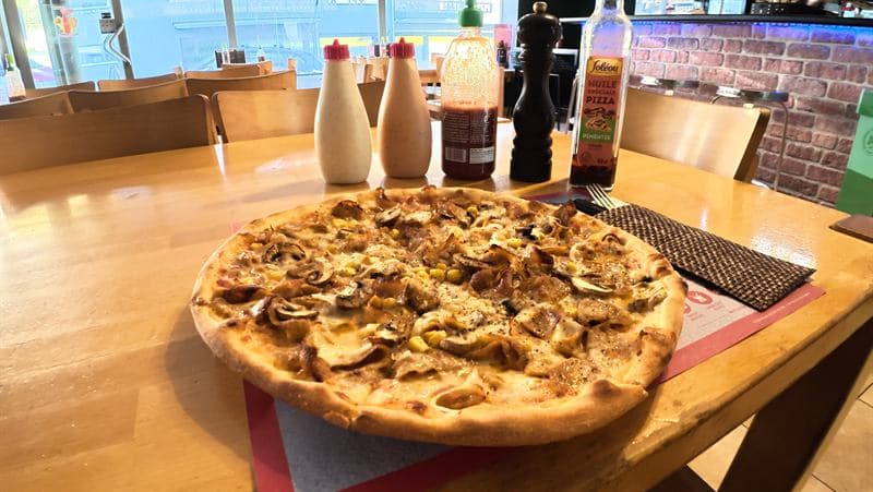 Frisch gebackene Pizza auf dem Tisch im Gastraum