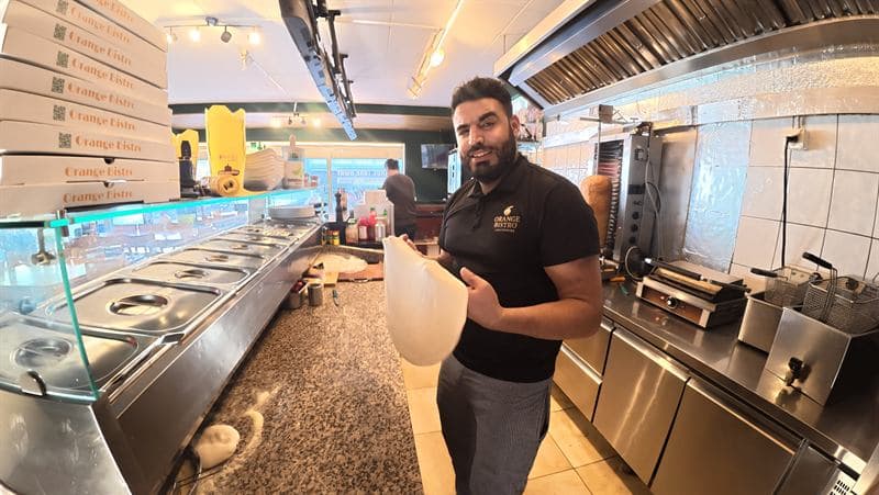 Der von Hand ausgezogene Teigfladen wird hochgehalten